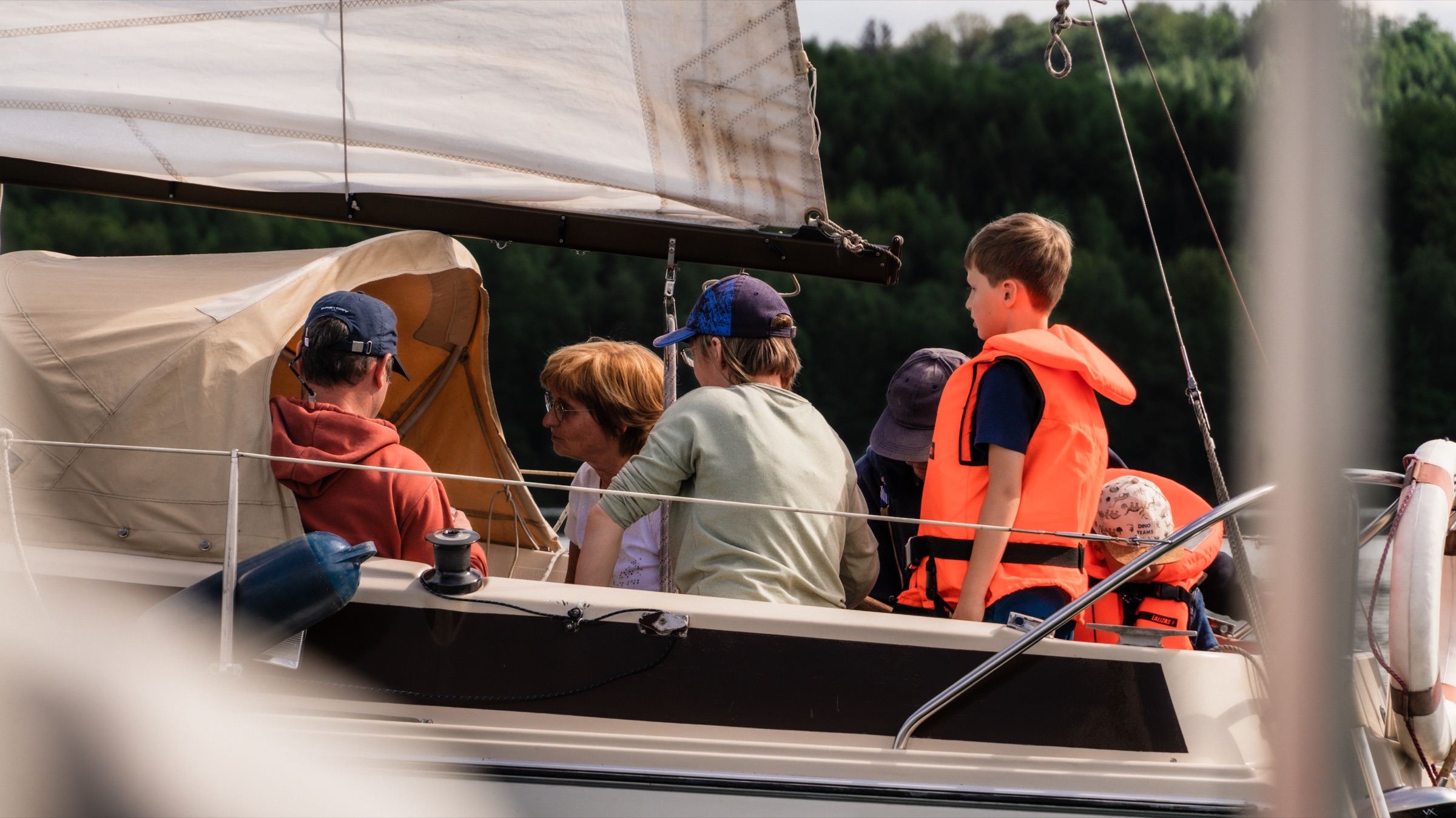 Familie mit Kindern in Schwimmwesten gemeinsam auf dem Segelboot