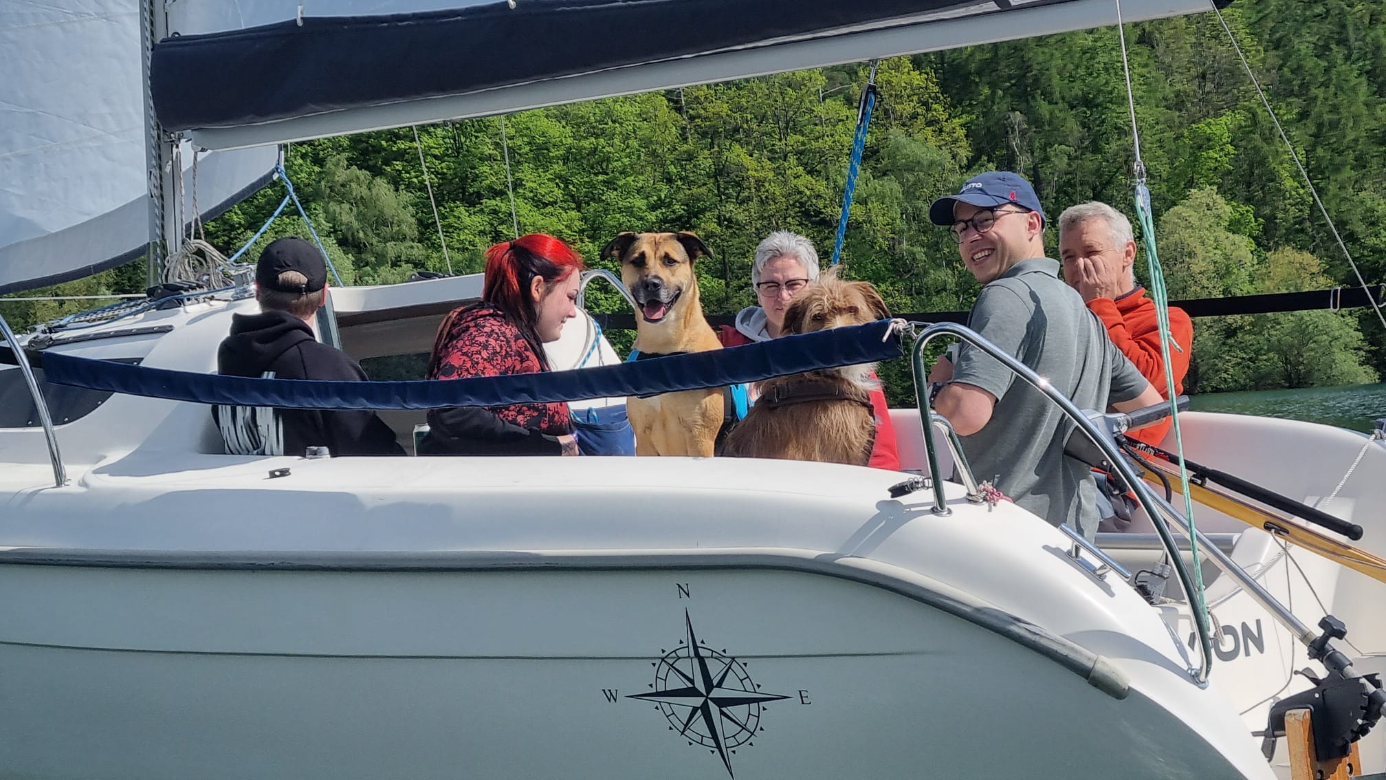 Zwei Hunde mitten in der Crew an Bord der AVION — einer schaut direkt in die Kamera